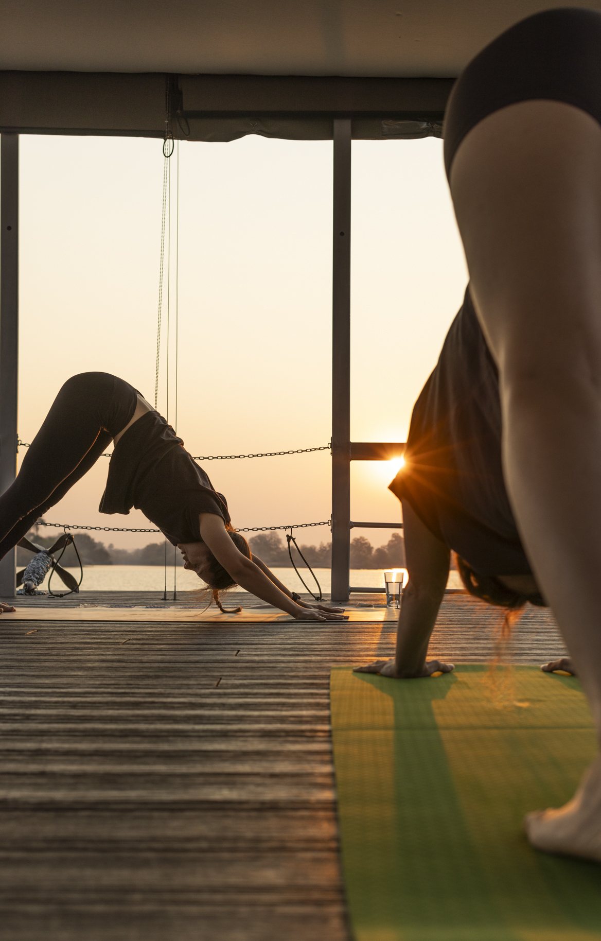 Downward dog pose on the Zambezi river deck at sunset